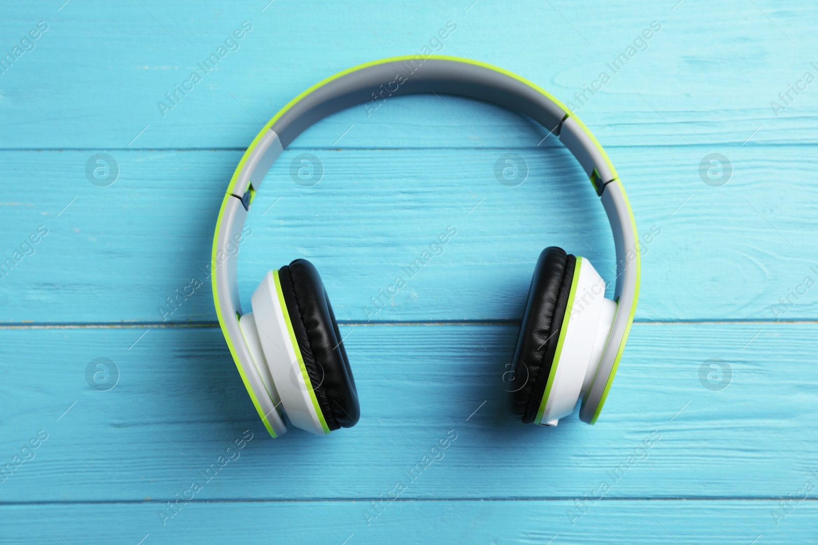 Photo of Stylish modern headphones on wooden background, top view