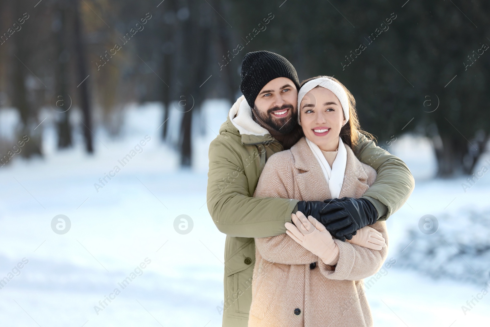 Photo of Beautiful young couple enjoying winter day outdoors. Space for text