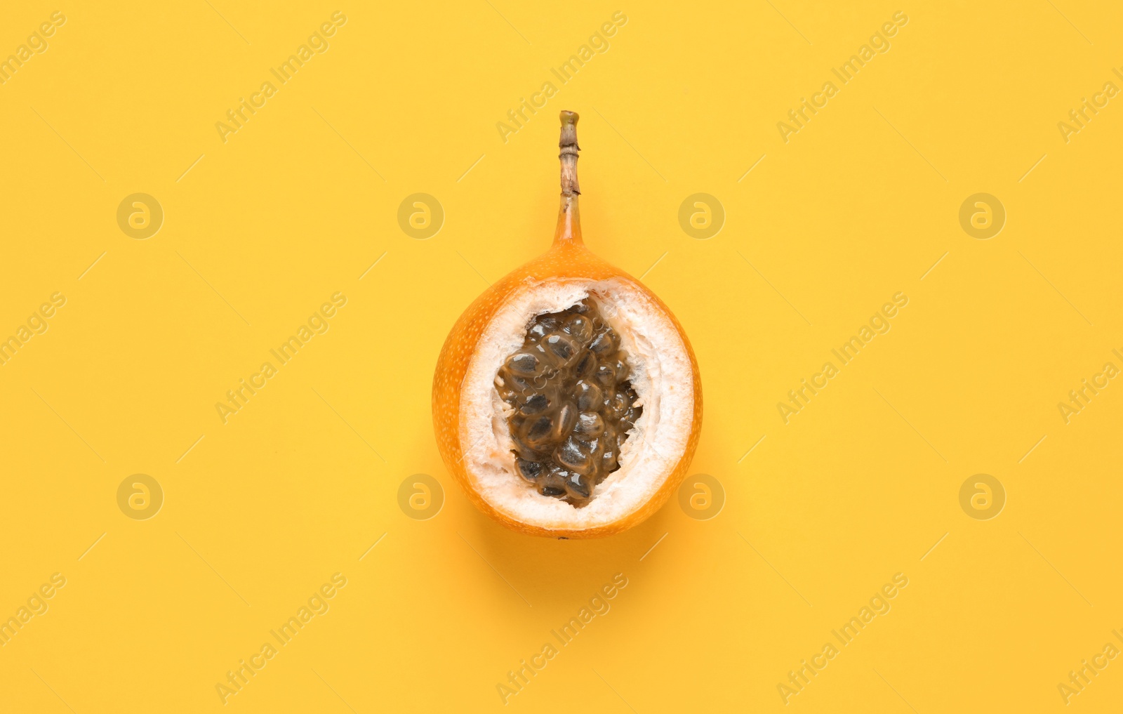 Photo of Delicious ripe granadilla on yellow background. top view