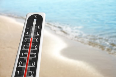 Image of Weather thermometer and beautiful seashore. Heat stroke warning