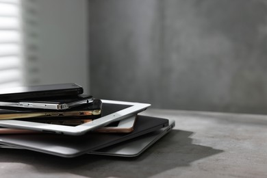 Photo of Many different modern gadgets on grey table indoors. Space for text