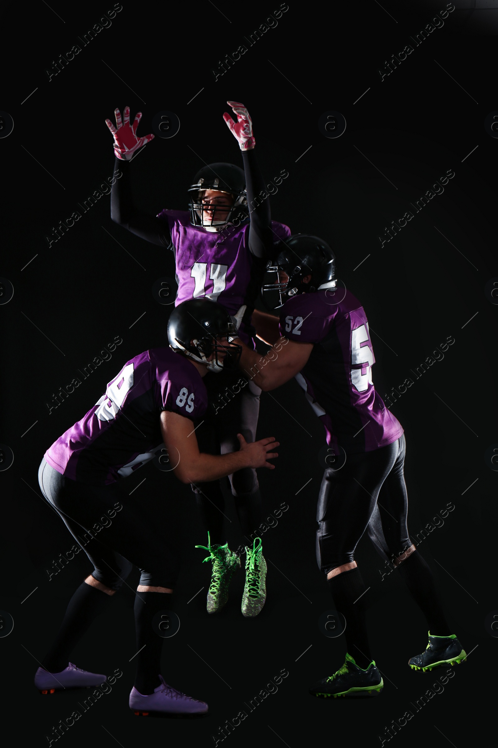 Photo of Men in uniform playing American football on dark background