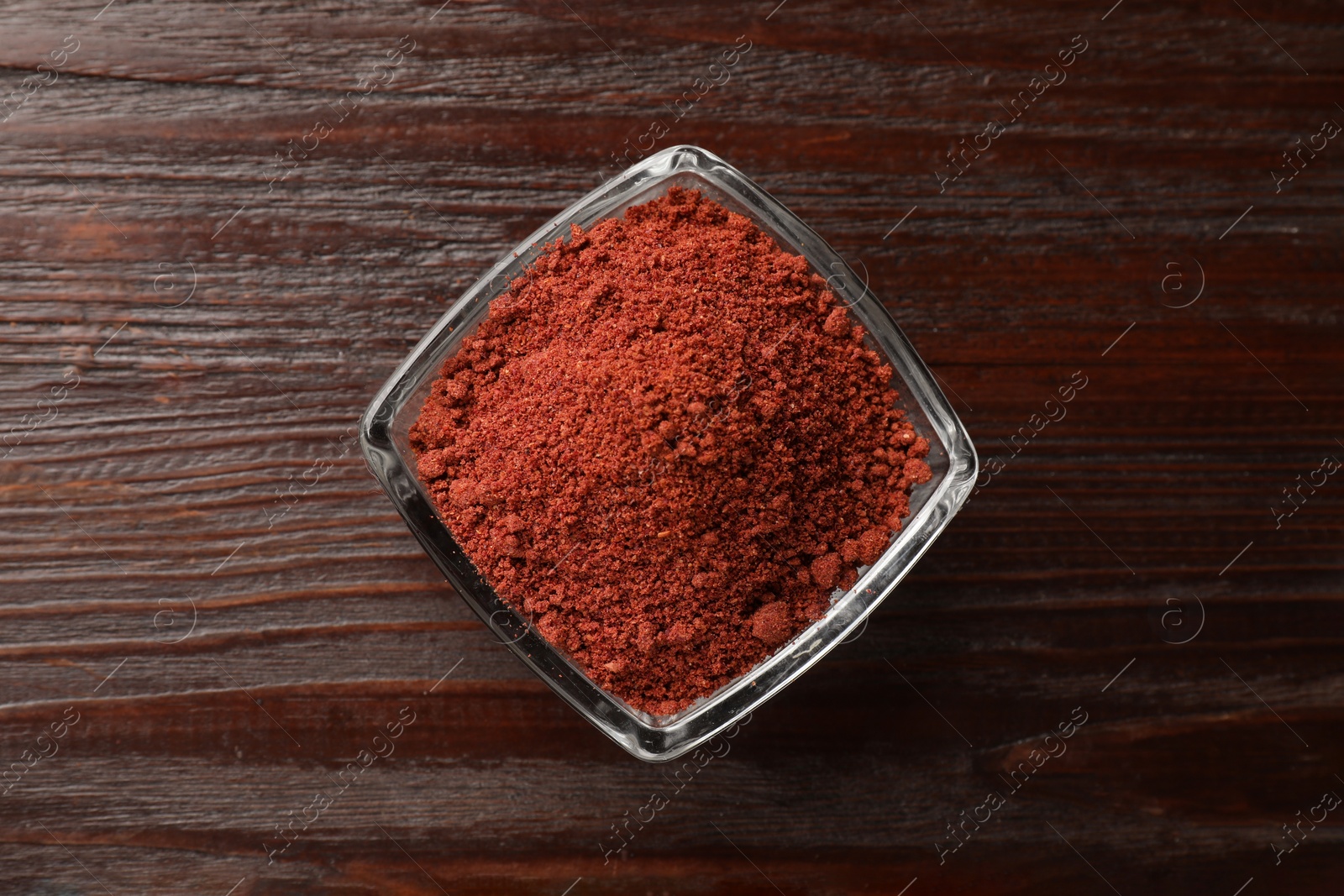 Photo of Dried cranberry powder in glass bowl on wooden table, top view