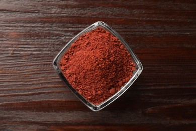 Photo of Dried cranberry powder in glass bowl on wooden table, top view