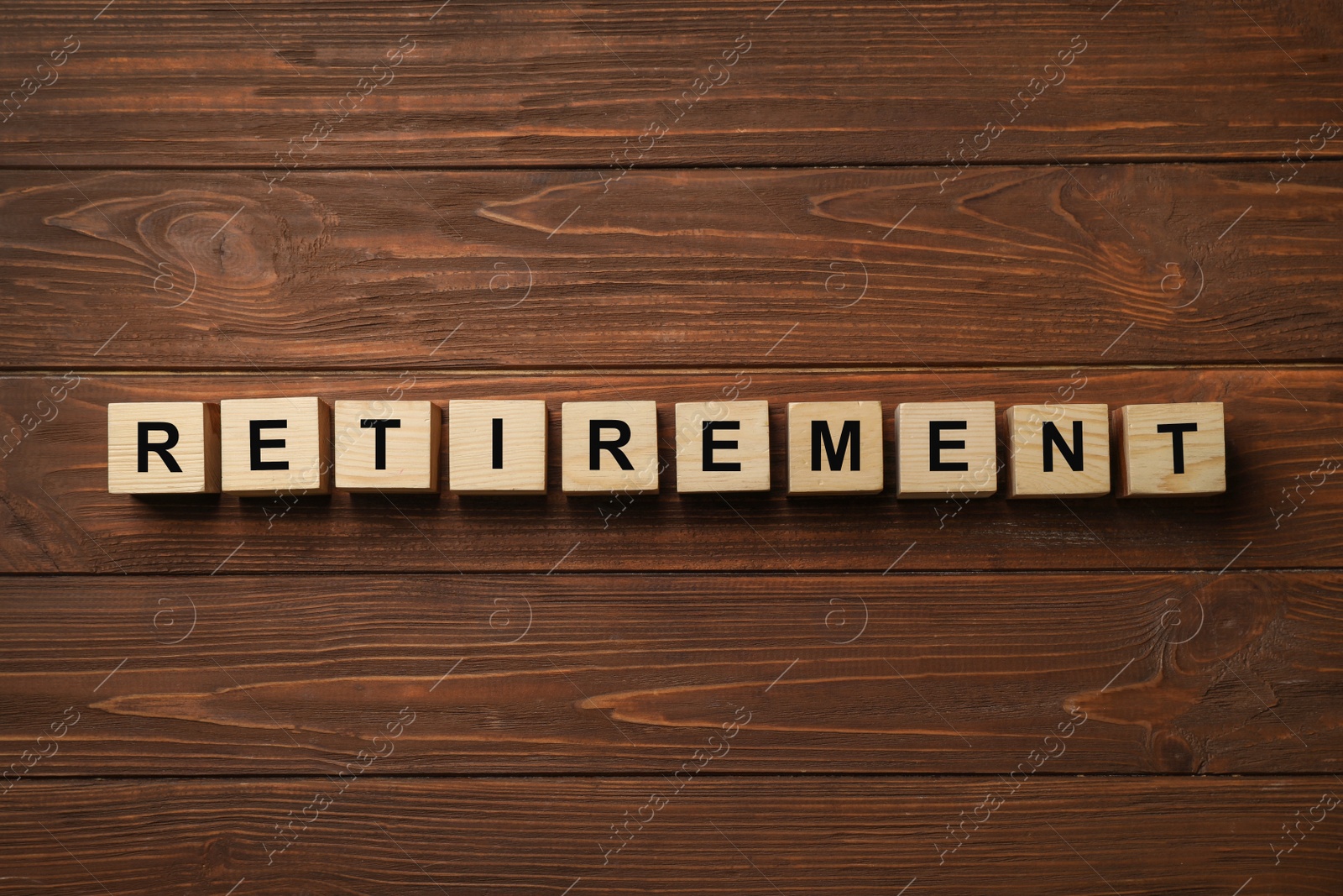 Photo of Cubes with word "RETIREMENT" on wooden background. Pension planning concept
