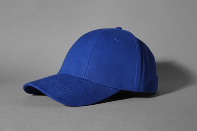 Photo of Stylish blue baseball cap on grey background