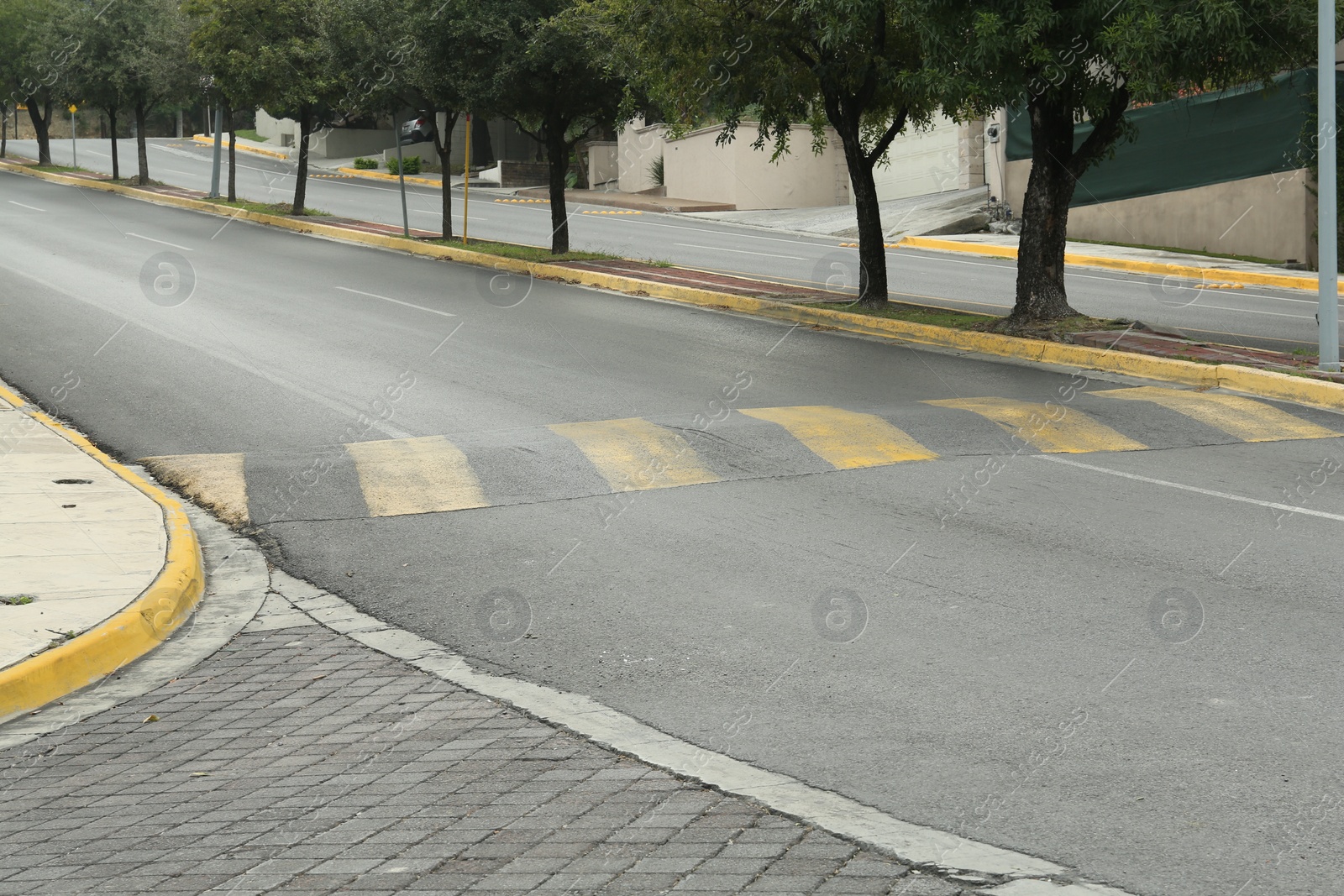 Photo of City street with striped concrete speed bump