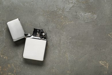 Photo of Metallic cigarette lighter on gray textured background, top view. Space for text
