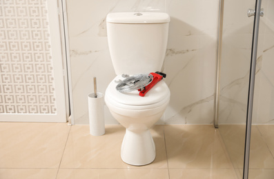 Photo of Plumber's tools on toilet bowl in bathroom