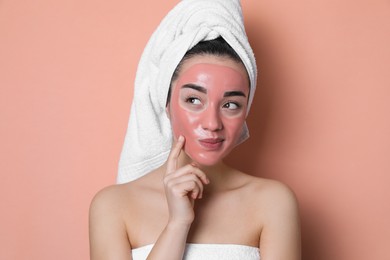 Photo of Woman with pomegranate face mask on pale coral background