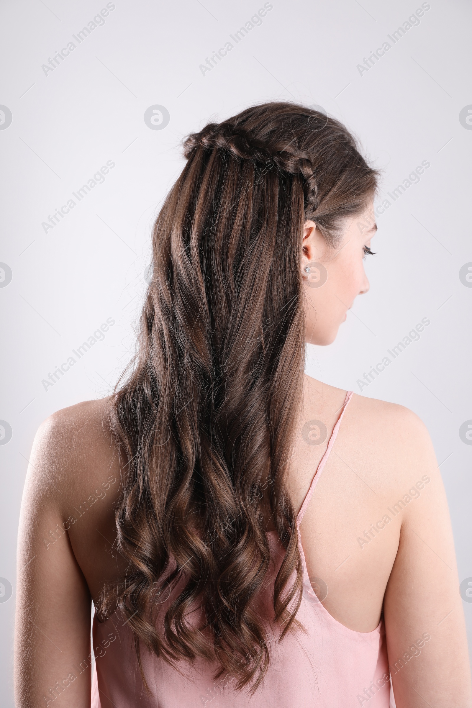 Photo of Woman with braided hair on light background, back view