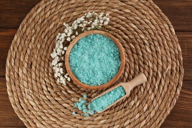 Photo of Bowl and spoon with sea salt, beautiful flowers on wooden table, flat lay