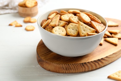 Photo of Delicious crispy crackers on white table, closeup