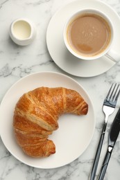 Photo of Delicious fresh croissant served with coffee on light marble table, flat lay