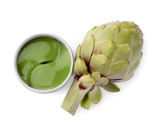 Photo of Package of under eye patches and artichoke on white background, top view. Cosmetic product