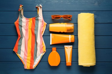 Photo of Different beach objects on blue wooden background, flat lay