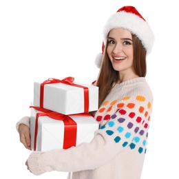 Photo of Happy young woman in Santa hat and sweater with gift boxes on white background. Christmas celebration