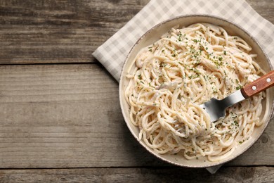 Photo of Delicious pasta with mushroom sauce served on wooden table, top view. Space for text