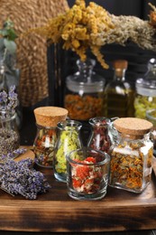Photo of Many different herbs and dry lavender flowers on wooden board