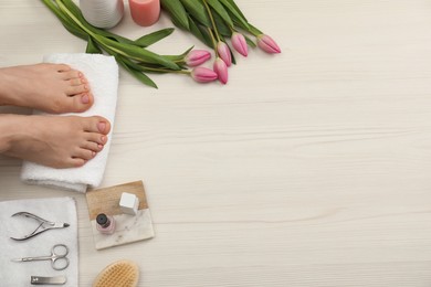 Photo of Woman with neat toenails after pedicure procedure on white wooden floor, top view