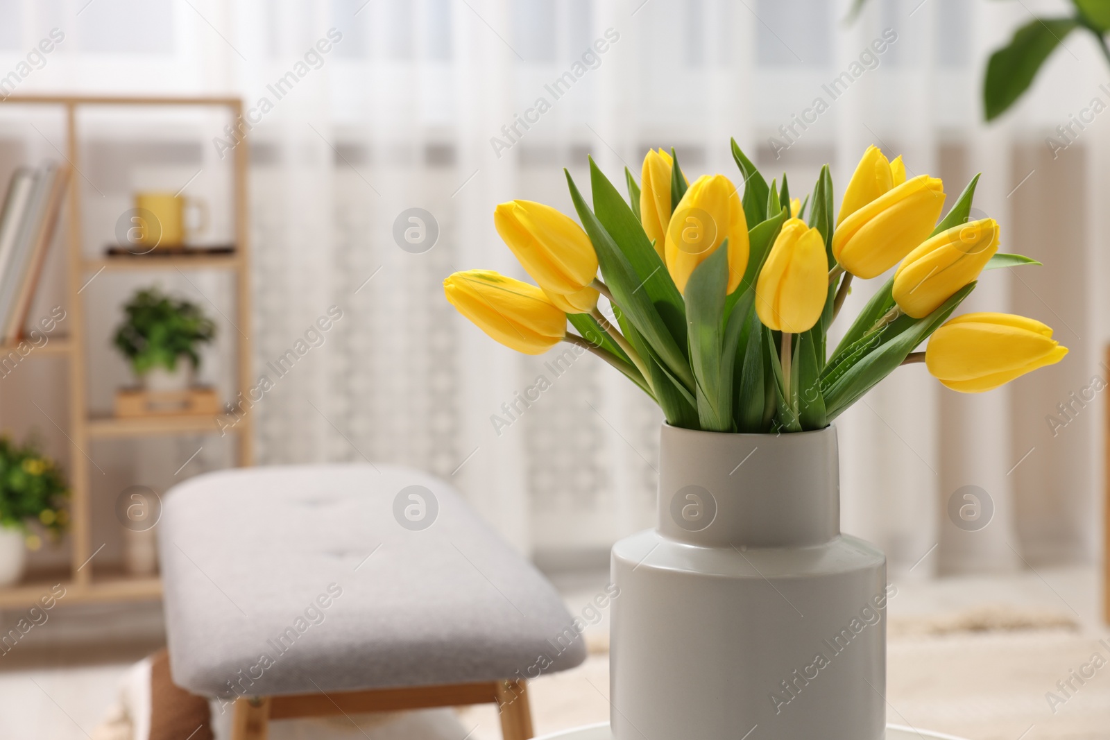 Spring interior. Bouquet of beautiful yellow tulips in living room, space for text Photo of Spring interior. Bouquet of beautiful yellow tulips in living room, space for text