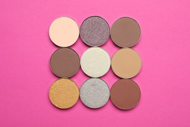 Photo of Beautiful eye shadow refill pans on pink background, flat lay