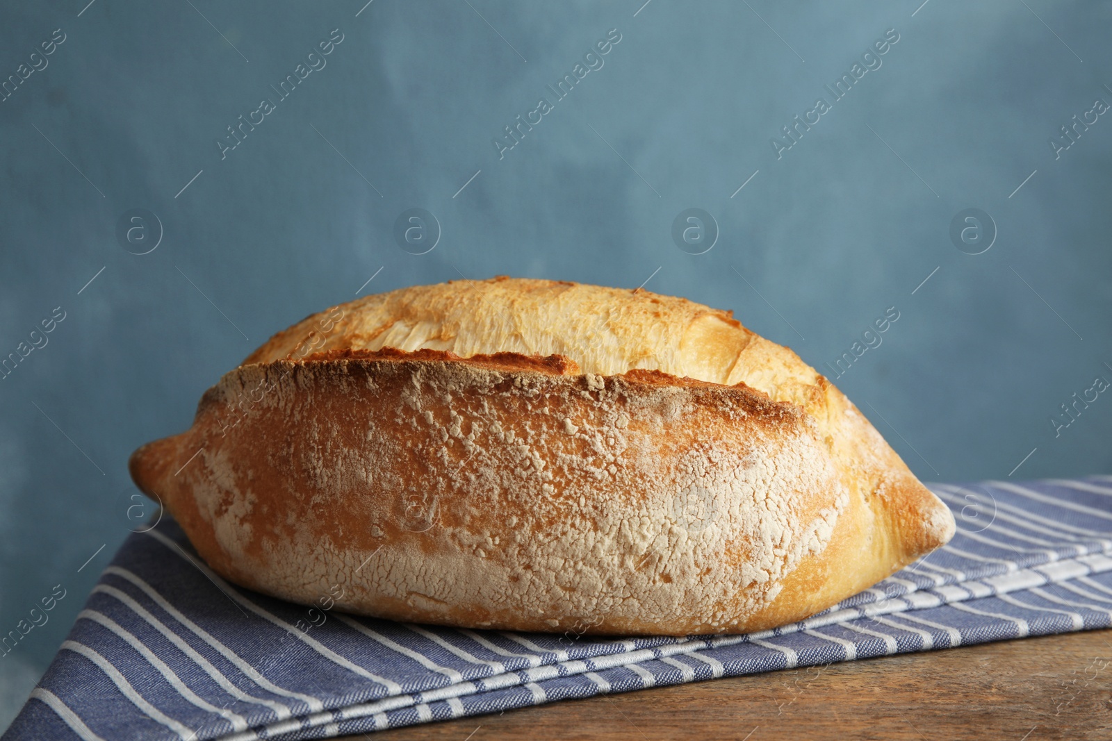 Photo of Fresh bread on table against color background