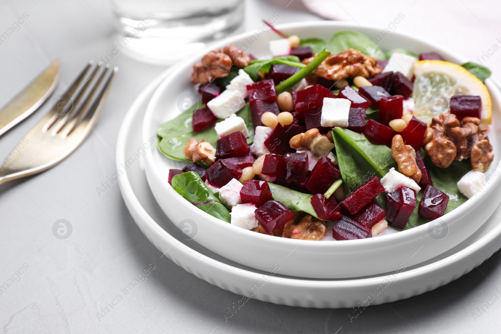 Photo of Delicious beet salad served on grey table, closeup