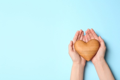 Photo of Woman holding heart on blue background, top view with space for text. Donation concept