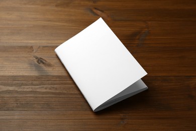 Photo of Blank paper brochure on wooden table. Mockup for design