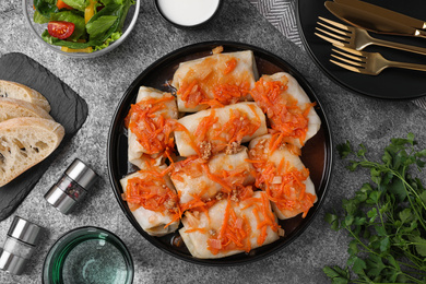 Photo of Delicious cabbage rolls served on grey table, flat lay