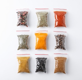 Photo of Plastic bags with different spices on white background, top view