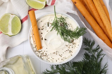 Photo of Delicious cream cheese with grissini stick and ingredients on white tiled table, flat lay