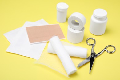 Photo of White bandage rolls and medical supplies on yellow background