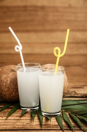 Photo of Composition with glasses of coconut water on wooden background