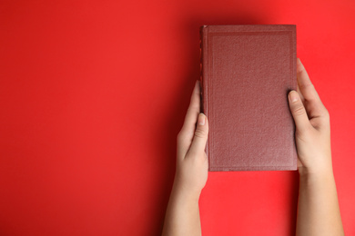 Woman with book on red background, top view. Space for design