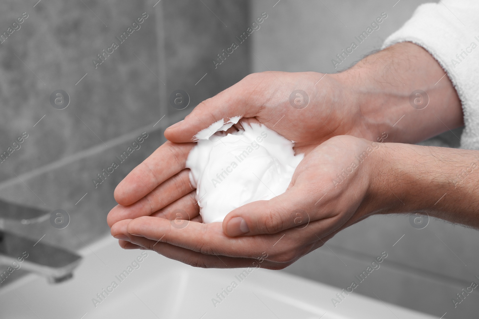 Photo of Man holding shaving foam in bathroom, closeup