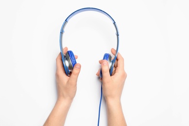 Photo of Woman holding stylish headphones on white background, closeup