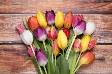 Photo of Beautiful colorful tulip flowers on wooden table, top view