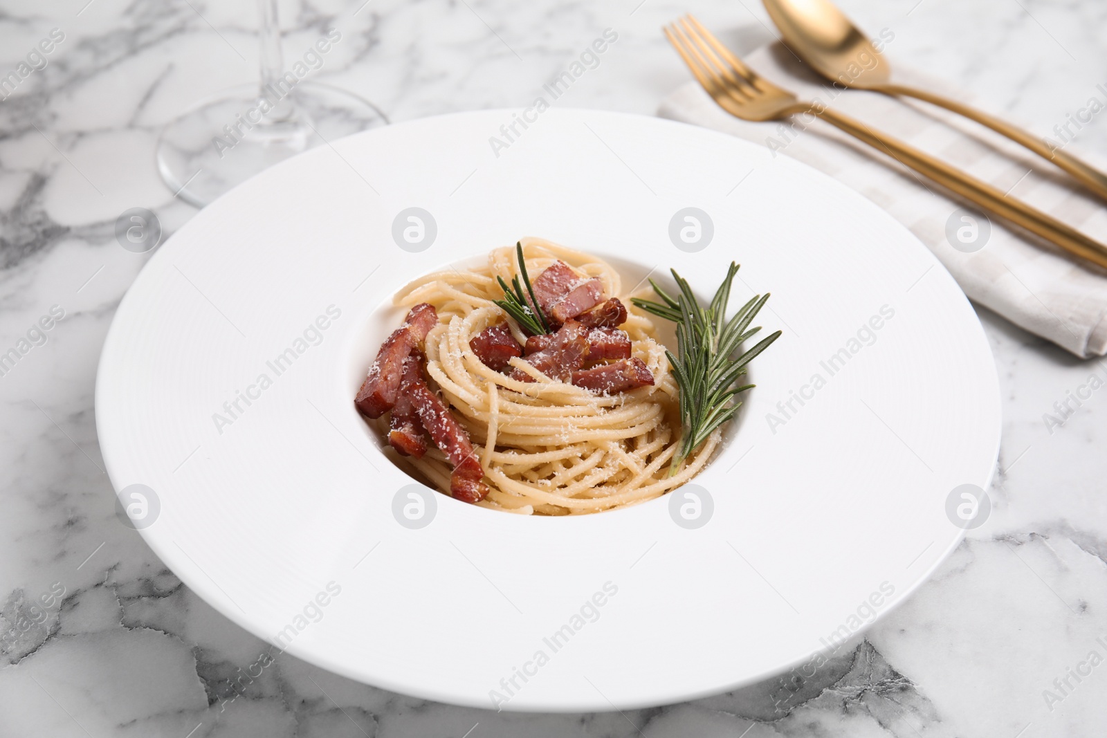 Photo of Delicious Carbonara pasta on white marble table