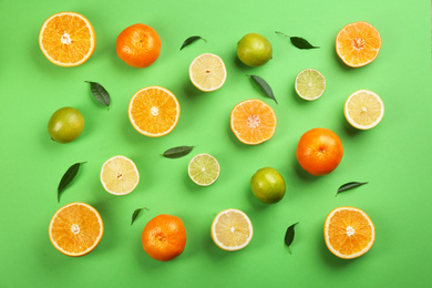 Photo of Flat lay composition with tangerines and different citrus fruits on green background