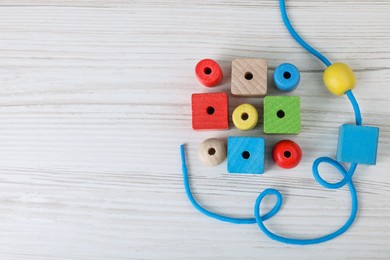 Photo of Wooden lacing toy on light table, top view and space for text. Motor skills development