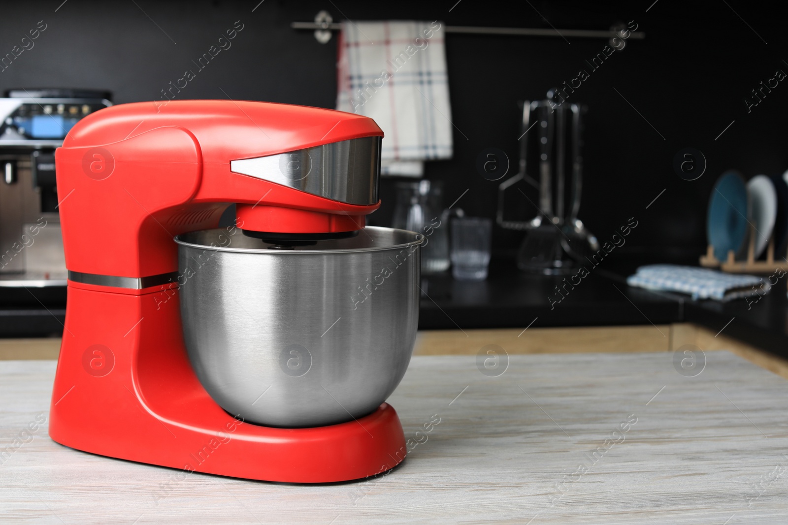 Photo of Modern stand mixer on wooden table in kitchen, space for text