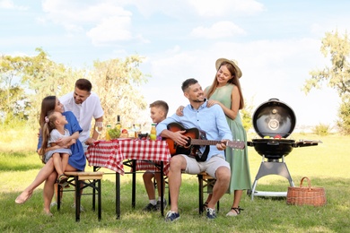 Photo of Happy families with little children having picnic in park