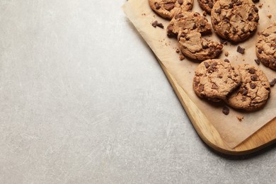 Photo of Many delicious chocolate chip cookies on grey table, top view. Space for text