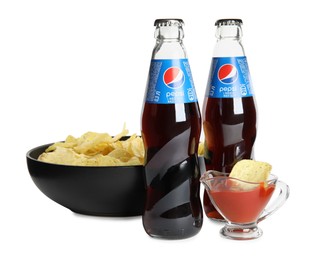 Photo of MYKOLAIV, UKRAINE - FEBRUARY 16, 2021: Glass bottles of Pepsi, chips and dip sauce isolated on white