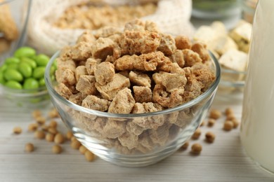 Photo of Dehydrated soy meat and other organic products on white wooden table, closeup