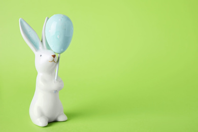 Photo of Easter bunny figure on green background. Space for text