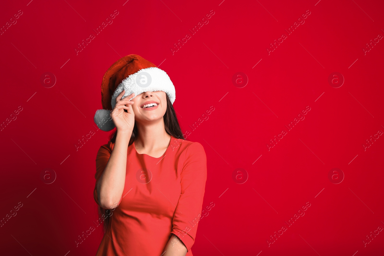 Photo of Young beautiful woman in Santa hat on color background. Christmas celebration