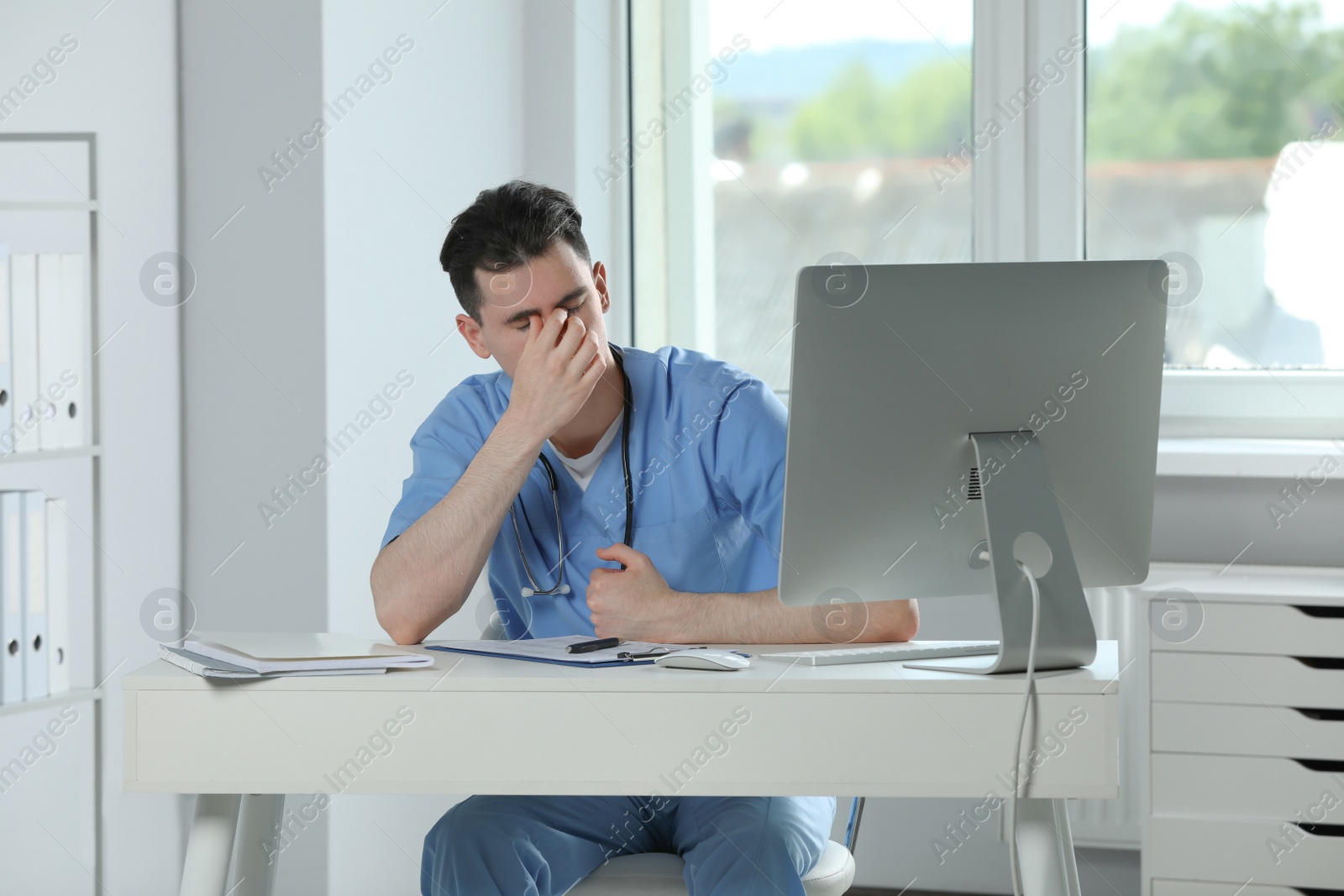 Photo of Exhausted doctor working at table in hospital